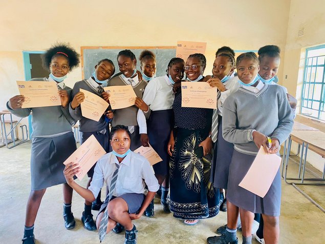 A class of female pupils showing certificates