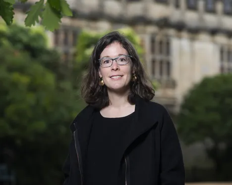 Emily Katzenstein steht auf einem Universitätscampus und lächelt