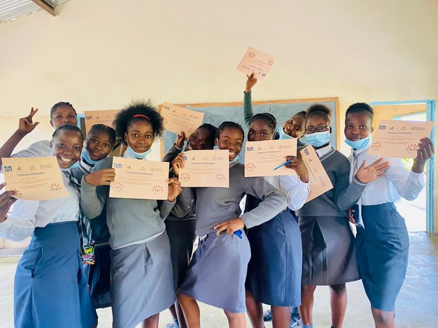 A group of female pupils showing their class certificates